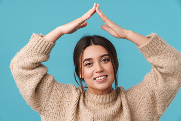 Image of happy caucasian woman smiling and showing home sign