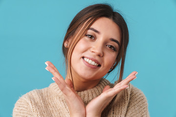 Image of happy caucasian woman in sweater smiling and looking at camera