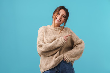 Image of happy caucasian woman smiling and pointing finger aside