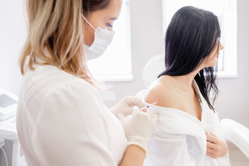 An unidentified immunologist picking up a vaccine into a vaccination syringe for a young female client. ?oncept of immunization against diseases and viruses. Medicine concept