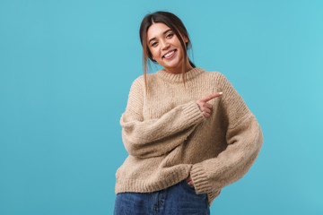 Image of happy caucasian woman smiling and pointing finger aside