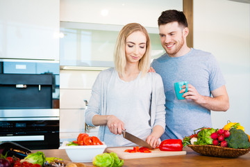 young happy couple preparing food at home