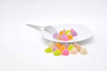 colorful Thai style dessert like mini meringue cookies put on plate with fork isolated on white background