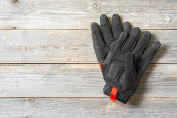 Construction gloves on grey wooden background. Top view with space for text