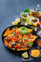 Chips nachos with beef, guacamole, chili, cheese salsa, tequila