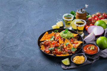Chips nachos with beef, guacamole, chili, cheese salsa, tequila