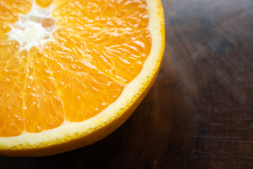 Orange cut in half on rustic wooden table