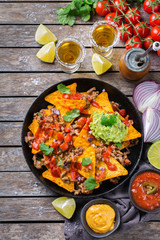Chips nachos with beef, guacamole, chili, cheese salsa, tequila