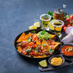 Chips nachos with beef, guacamole, chili, cheese salsa, tequila