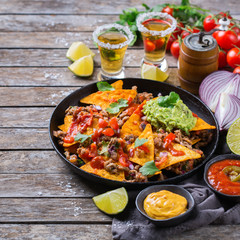 Chips nachos with beef, guacamole, chili, cheese salsa, tequila