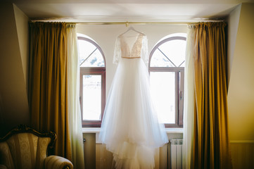 Wedding dress hanging in bedroom