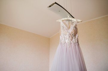 Beautiful wedding dress hanging in interior