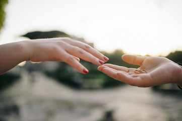 Young couple in love is holding wedding rings in hands