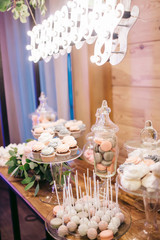 Wedding. Sweets, candies, snacks, cakes are on wooden the table