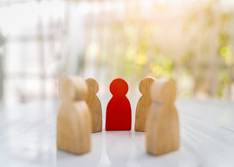 Figure in human resource management concept. The group of wooden puppets is a circular. A red...