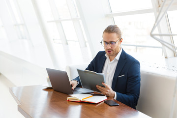 Handsome young businessman holding clipboard.