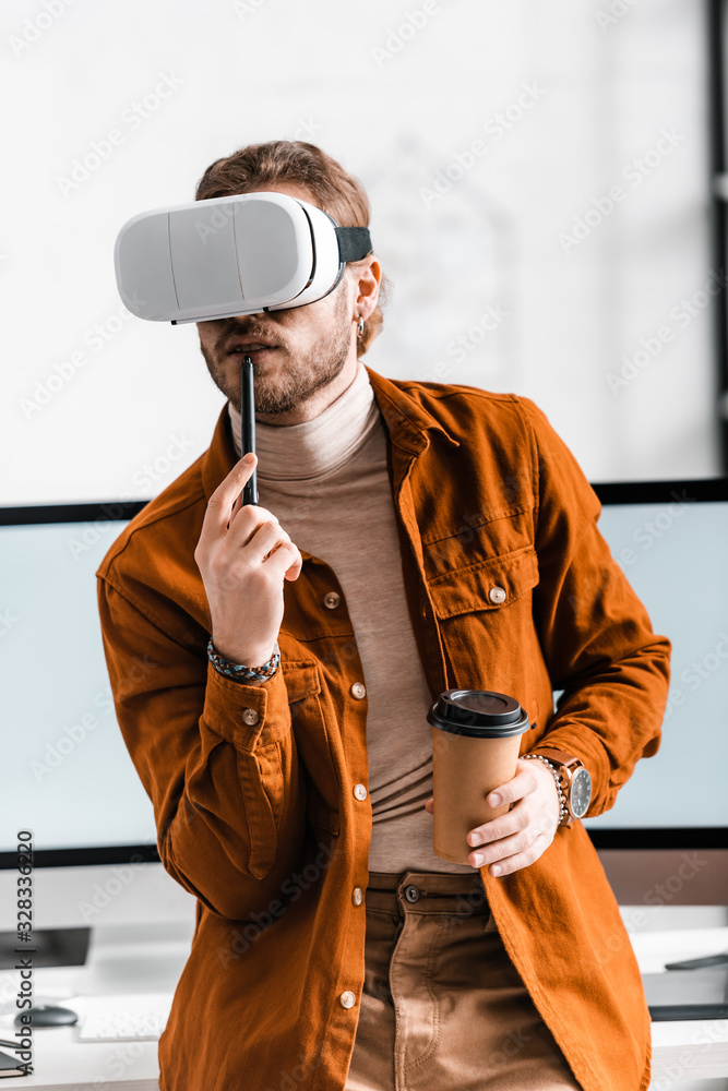 Poster digital designer in vr headset holding stylus of graphics tablet and coffee to go near computer moni