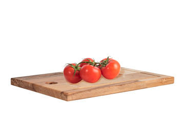 branch of ripe red tomato on a new hardwood kitchen board isolated on white background