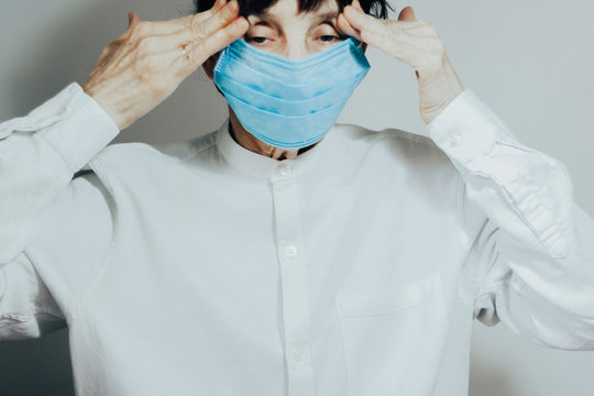 Coronavirus quarantine and Air pollution pm2.5 concept. Sick sad depressed, thoughtful old woman wearing respirator mask for protect. Wuhan, China epidemic virus symptoms background.