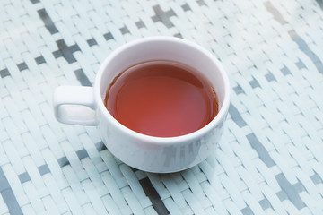 Black tea in white cup. The cup of herbal tea on table.