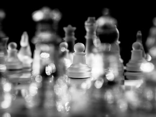 Abstract view on isolated enemy pawn chess piece. Selective focus black and white background.