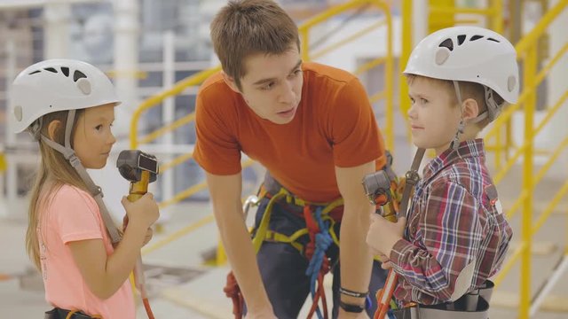 Rope park worker instructing little kids on safety measures