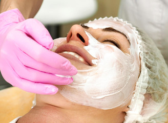 The doctor puts a white mask on the patient's face with his hand