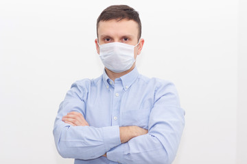 Portrait of a man on a white isolated background, face covered with a medical mask, banner for text. Health, awareness, and timeliness. Healthy lifestyle. No viruses.
