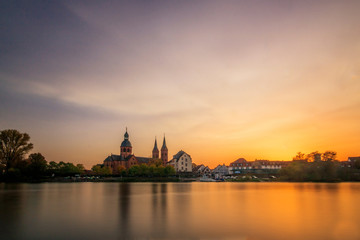 Fototapeta na wymiar sunset over the city, beautiful sunset or sunrise over an old monastery in Seligenstadt Hessen Germany. a nice long exposure over a liquid at sunset