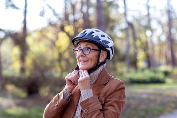 Mature woman with helmet on his head in park