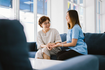 Young physical therapist consulting senior patient at health care clinic 