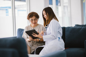 Young doctor consulting senior patient at health care clinic 