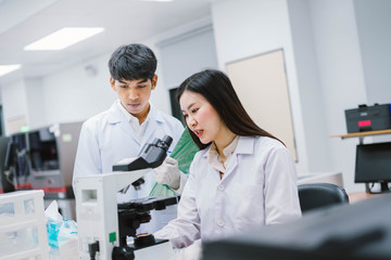 Two  medical  scientist consult at microscopic analysis in medical laboratory