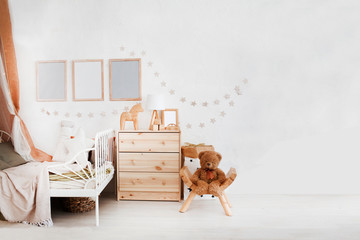 Stylish scandinavian  baby room with crib, dresser, wooden toys and lamp. zero waste. eco-friendly...
