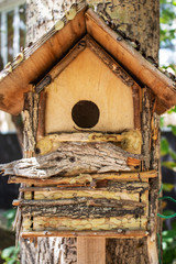wooden birdhouse hanging from tree. carpenter made