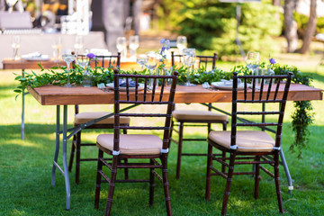 Fototapeta na wymiar Preparing for an open-air party. Decorated served tables await guests. Decoration Details