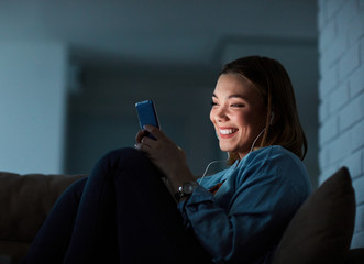 girl smartphone mobile phone night smiling earphones texting late glowing screen