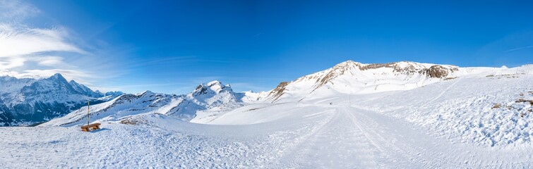 Fototapeta na wymiar Wide parnoramic view of snow covered Swiss Alps in Grindelwald ski resort, Switzerland