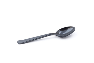 Single small black plastic baby teaspoon isolated from white background