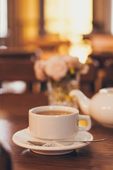 Beautiful fresh roses near a cup of tea and a in pastel tones romantic mood