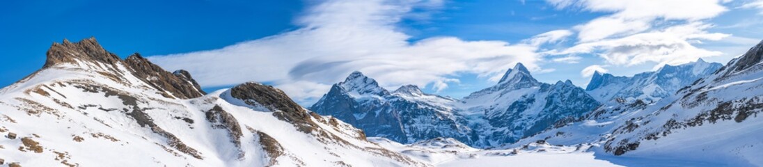 Obraz premium Wide parnoramic view of snow covered Swiss Alps in Grindelwald ski resort, Switzerland