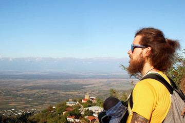 Naklejka premium Father is travelling in the mountains with his little daughter in ergo carrier.