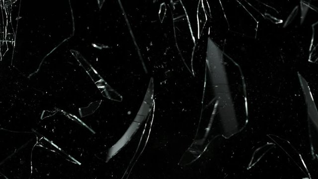 Super slow motion of shattered glass on black background. Filmed on high speed cinema camera, 1000 fps.