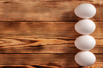 Eggs on a wooden table with the edge in a row. Copy space.