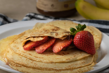 Delicious homemade crepes with strawberries, banana and chocolate