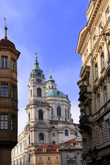 Fototapeta na wymiar view to St. Nicholas Church, also called Kostel Svateho Mikulase, in Prague, Czech Republic, with its dome seen from Karmelitska street, in the Mala Strana District, of the old town