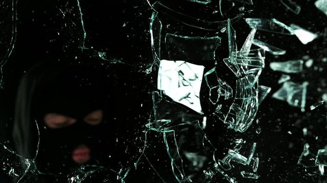 Detail of shattered glass, burglar on background