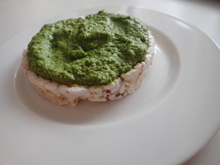   round rice bread with green basil pesto