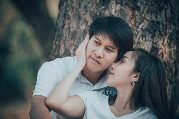 Fototapeta premium Portrait of young asian couple in love in the forest,Thailand people happy to be together,Valentine day concept