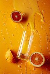 Orange juice with fruits on a yellow background.